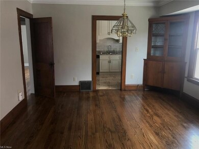 Hardwood floored empty room featuring crown molding