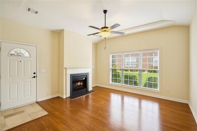 Unfurnished living room with a fireplace with flush hearth, hardwood / wood-style flooring, and a ceiling fan