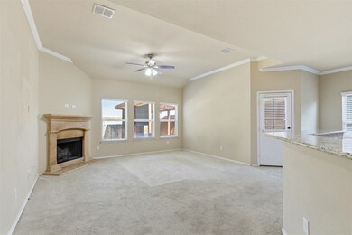 Unfurnished living room featuring crown molding, light colored carpet, a premium fireplace, and a ceiling fan