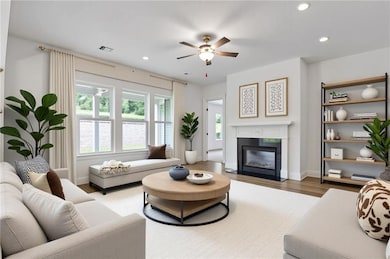 Living area with recessed lighting, wood finished floors, ceiling fan, and a fireplace with flush hearth