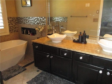 Full bathroom with double vanity, a freestanding b