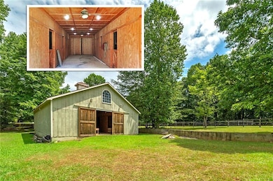 Rear view of house featuring an outbuilding and view of wooded area
