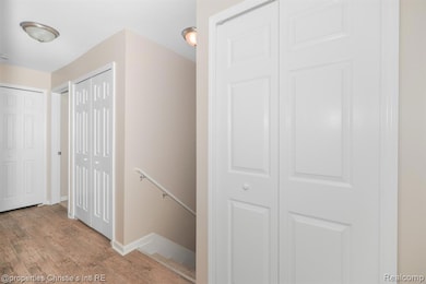 Hallway featuring an upstairs landing and light wood finished floors