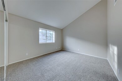 Primary bedroom features vaulted ceiling and mirro