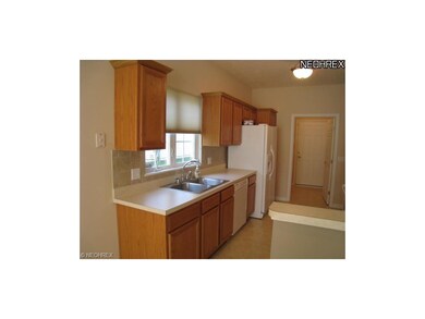 Fully applianced kitchen with tile backsplash.