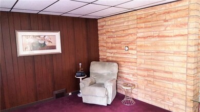 Two living room walls and paneled. A third wall re