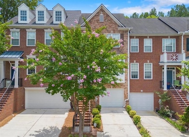 Townhome / multi-family property with driveway, brick siding, and an attached garage