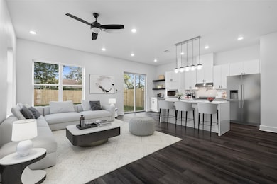 Virtually staged living room showcasing an open and inviting layout, with modern seating and natural light flowing into the kitchen