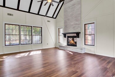 Unfurnished living room featuring ceiling fan, bea