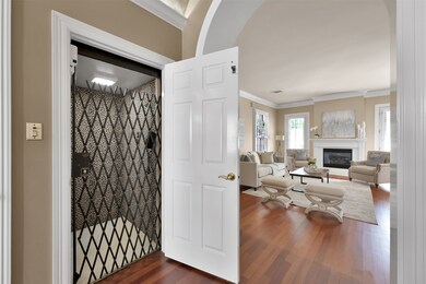 Light filled living room with fireplace, hardwoods & plantation shutters.