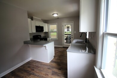 Kitchen featuring kitchen peninsula, white cabinet