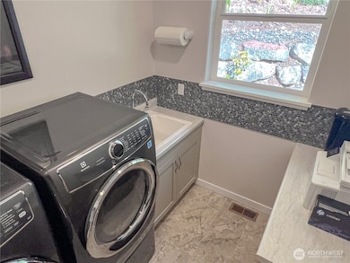 Also a handy deep sink in the utility room, window and aesthetically pleasing accent tilework.