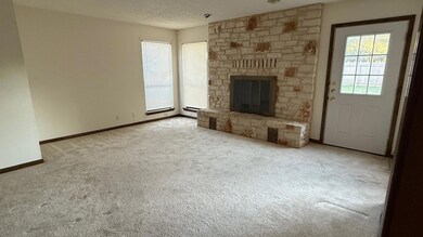 Unfurnished living room with a fireplace, carpet, and a textured ceiling