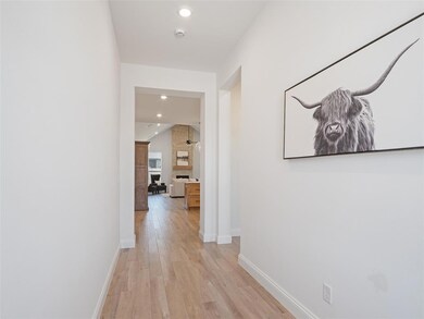 Hallway with light wood-style floors, baseboards, and recessed lighting