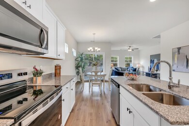 Kitchen featuring a sink, light stone counters, ap