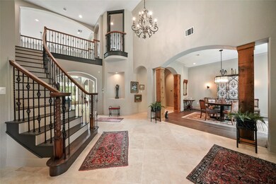 Entryway of the home shows the updated tile flooring along with brand new hardwood flooring on stairs, formal dining, and formal living (just out of view here). Upgraded wrought iron rails were used for the spindles of the staircase to add to the over-all appeal. New updated light fixtures here and throughout the home.