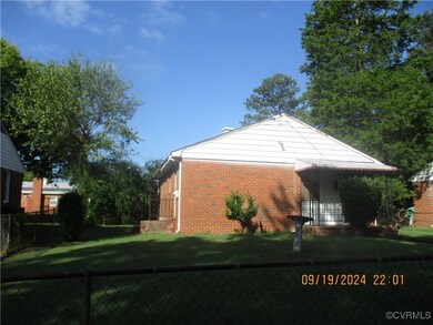 View of side of home with a yard