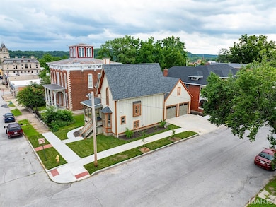 View of front of property with a shingled roof, a garage, concrete driveway, and a front lawn