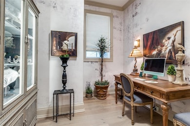 Office area with baseboards, crown molding, and li