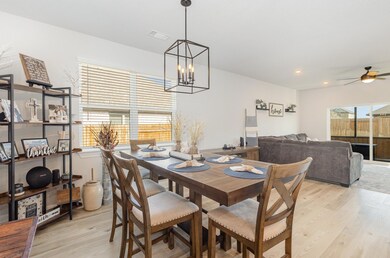 Dining room with light wood-style floors, a chand