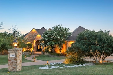 View of front facade with a lawn, stone siding, a