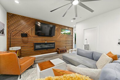 Living room featuring an accent wall, wood finish