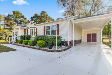 View of side of home featuring an attached carport, driveway, and covered porch