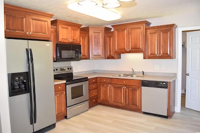 Kitchen with light wood-style floors, light countertops, a sink, and appliances with stainless steel finishes
