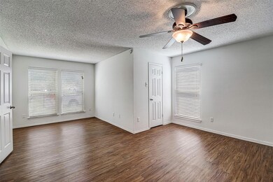 Empty room with dark wood-type flooring, ceiling f