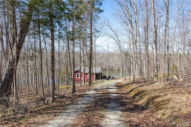 View of road with a wooded view and driveway