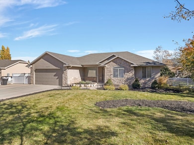 Ranch-style home with driveway, stone siding, an attached garage, and stucco siding