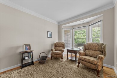 Formal living room with hardwood floors and crown molding