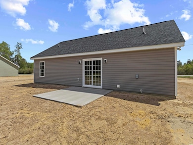 Back of house featuring a shingled roof and a patio area
