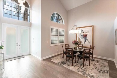 Dining area featuring high vaulted ceiling, wood finished floors, and french doors