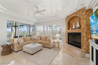 Living area featuring a tray ceiling, a ceiling fa