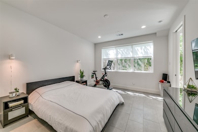Bedroom with light tile patterned flooring and recessed lighting