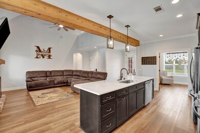 Kitchen featuring beamed ceiling, sink, ceiling fa