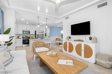 Living room with light tile patterned floors, recessed lighting, and a tray ceiling