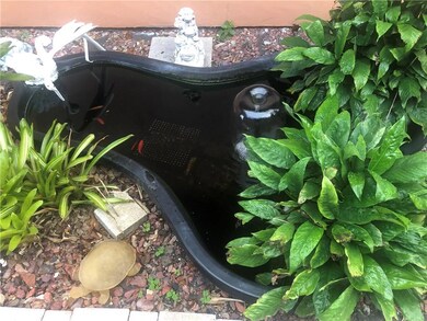 fish- pond with small goldfish left of entrance