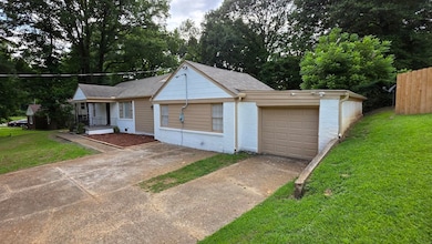 View of front facade featuring driveway, an attached garage, brick siding, a porch, and roof with shingles