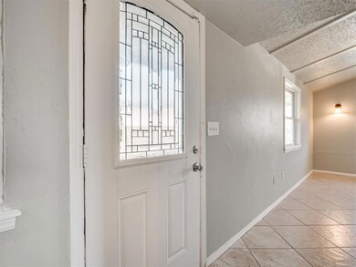 Entryway featuring baseboards, a textured ceiling,