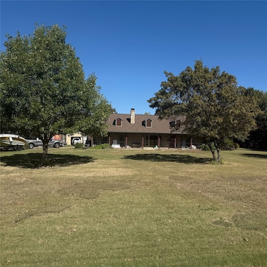 View of front of house featuring covered porch, a front lawn, and a chimney