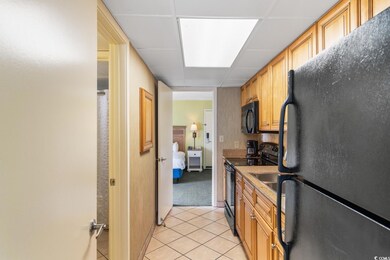 Kitchen with black appliances, a paneled ceiling, 