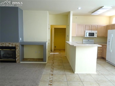 Kitchen with white appliances, and tiled flooring