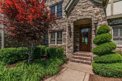 Recessed front door with mature landscaping 