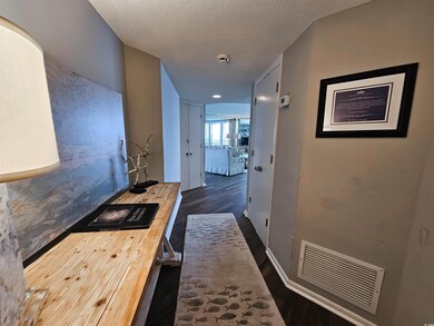 Hall with wood finished floors and a textured ceiling