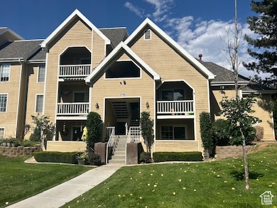 View of front of home with a balcony, a front lawn, and stairway