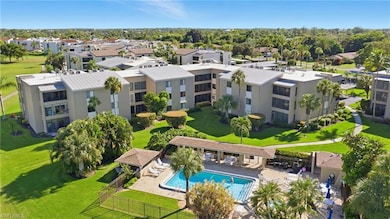 Drone / aerial view of a pool area and apartment complex / building