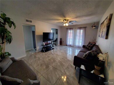 Living area featuring light marble finish flooring, a textured ceiling, and ceiling fan