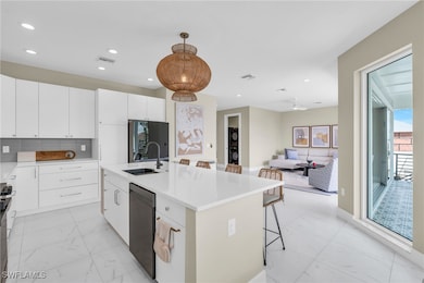 Kitchen featuring white cabinetry, sink, an island